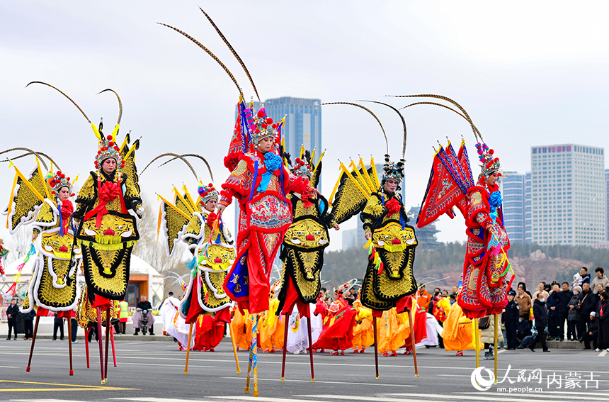 民间艺人在鄂尔多斯市2026年群众迎春年俗巡游活动中表演河北安新高跷。王正摄