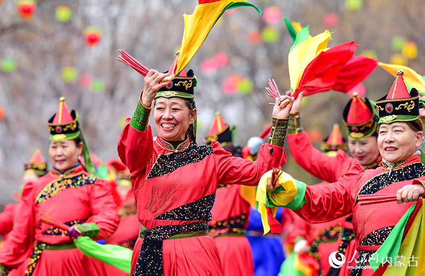 人们在鄂尔多斯市2026年群众迎春年俗巡游活动中表演筷子舞。王正摄