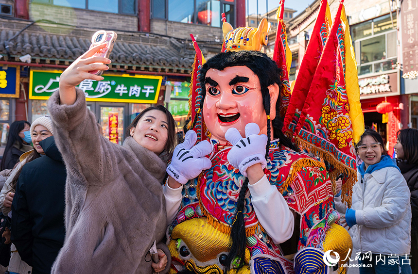 呼和浩特新春文化廟會非遺“鬧元宵”活動現場，游人與“電音三太子”拍照留影。丁根厚攝