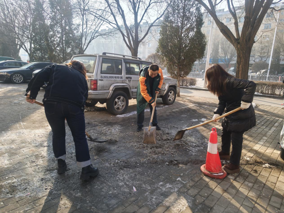 徐向东和社区居民们铲除路面结冰。顾源摄