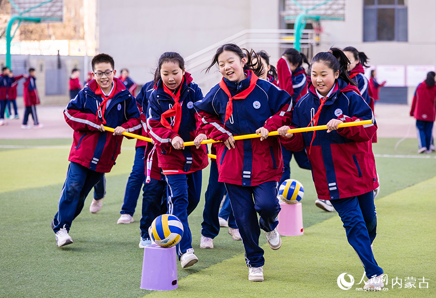 呼和浩特市玉泉区石东路小学学生在操场参加三人绕桩跑趣味游戏。丁根厚摄