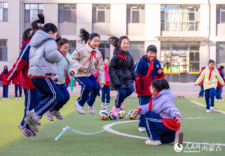 呼和浩特市玉泉区石东路小学学生在操场参加“跳扫乐”趣味游戏。丁根厚摄