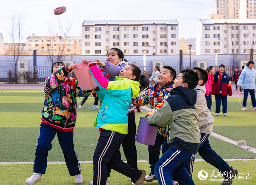 呼和浩特市玉泉区石东路小学学生在操场参加趣味接沙包游戏。丁根厚摄