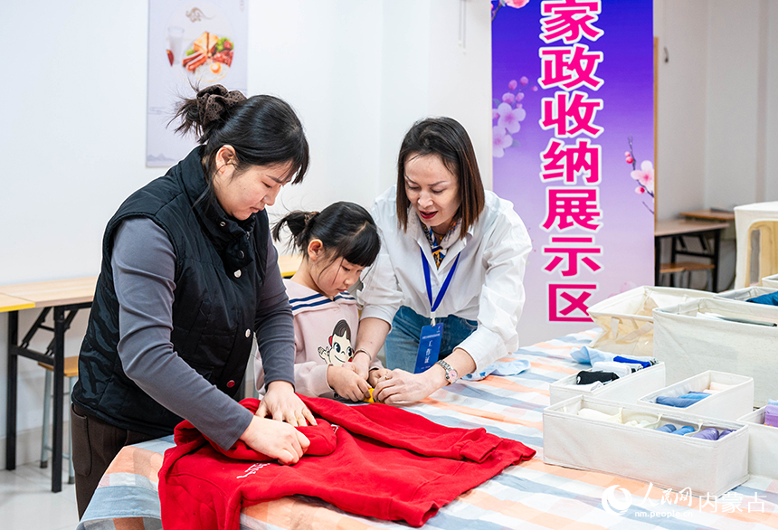 内蒙古呼和浩特市妇联巾帼创业就业主题活动现场，市民在学习体验家政收纳。丁根厚摄