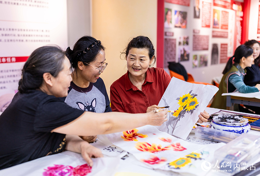 老年學員在玉泉區老年大學繪畫課上交流國畫技藝。丁根厚攝