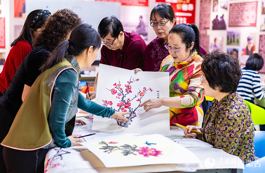 老年學員在玉泉區老年大學繪畫課上交流國畫技藝。丁根厚攝