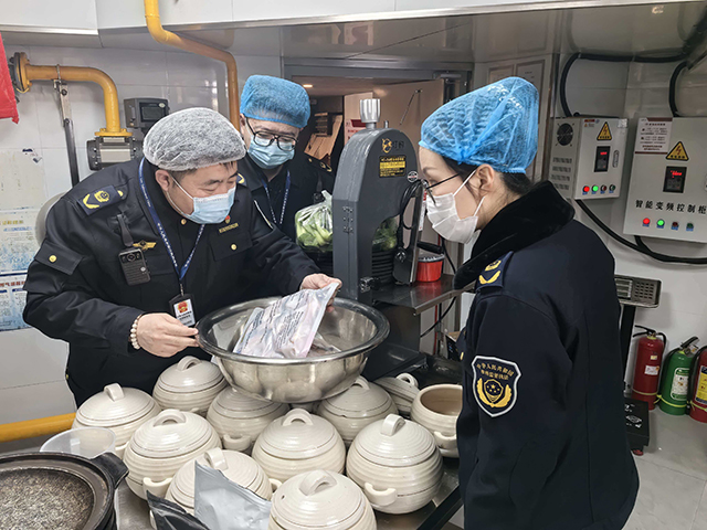 青山区市场监管局执法人员对辖区餐饮单位进行检查。