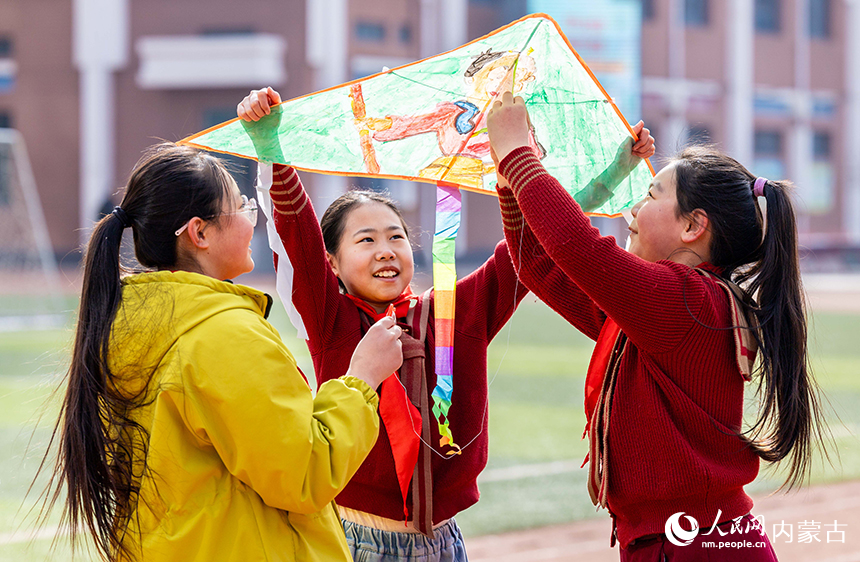 呼和浩特市玉泉区恒昌店巷小学五里营校区的学生在操场上系风筝提线，准备放飞。丁根厚摄