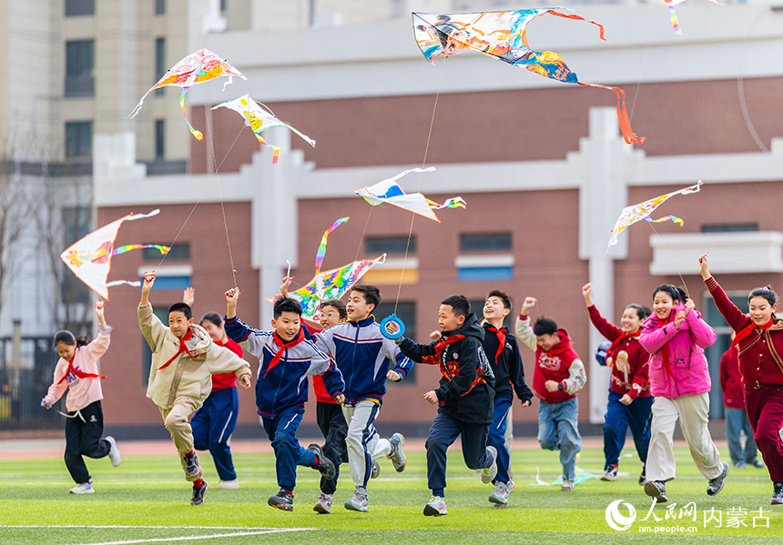 呼和浩特市玉泉區恆昌店巷小學五裡營校區的學生在操場上放飛風箏，感受春天的氣息。丁根厚攝