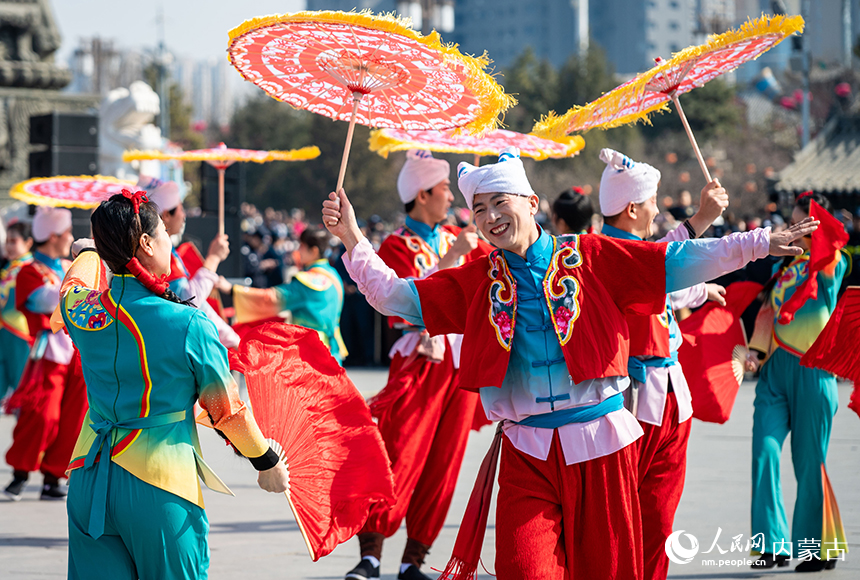 内蒙古呼和浩特市玉泉区“二月二”南北非遗民俗展演现场，陕北倩倩秧歌队的表演吸引游人驻足观看。丁根厚摄