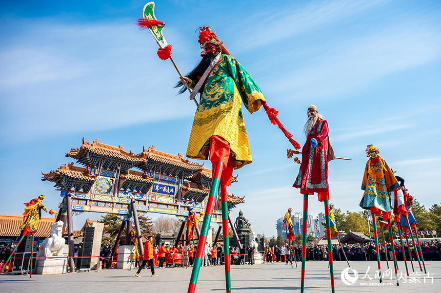 内蒙古呼和浩特市玉泉区“二月二”南北非遗民俗展演现场，“醉关公小林子”团队表演的高跷吸引游人驻足观看。丁根厚摄