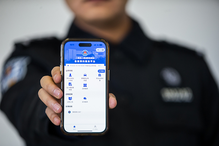 二连出入境边防检查站执勤民警展示“边检通”备案预约服务平台。郭鹏杰摄