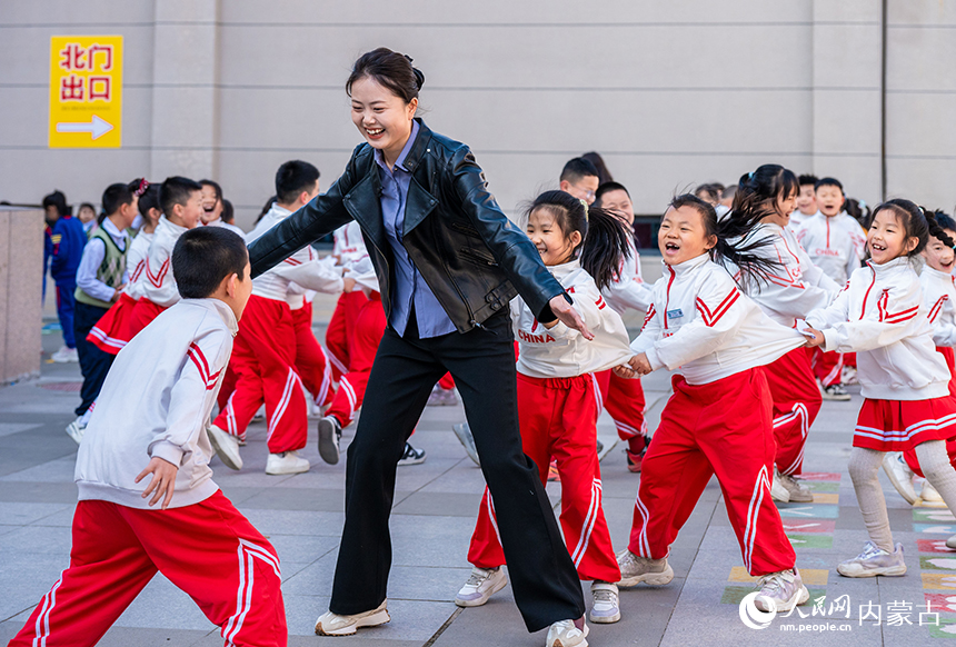 呼和浩特市南马路小学新华西街校区的师生在15分钟课间玩老鹰捉小鸡游戏。丁根厚摄