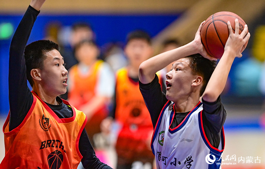 3月25日，呼和浩特市赛罕区大学路小学队球员（左）在比赛中防守。王正摄