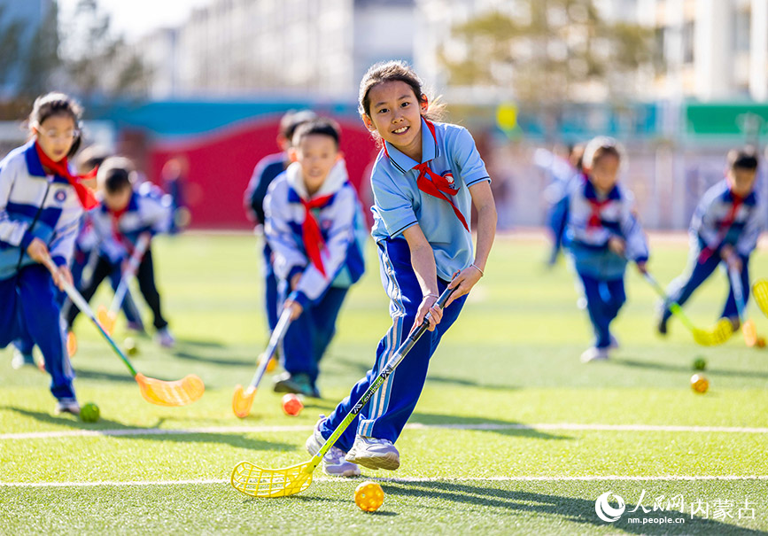 3月26日，呼和浩特市玉泉区通顺街小学曲棍球社团的学生在进行运球练习。丁根厚摄