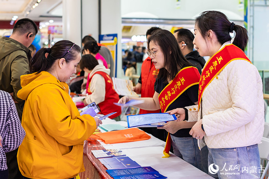 3月28日，呼和浩特市玉泉区“春风行动”暨就业援助季专场招聘会现场，工作人员向求职者发放“24小时智能政务服务”宣传材料。丁根厚摄