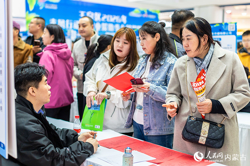 3月28日，呼和浩特市玉泉区“春风行动”暨就业援助季专场招聘会现场，求职者在寻找心仪岗位。丁根厚摄
