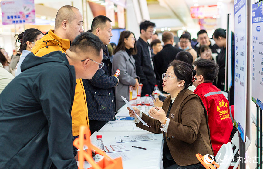 3月28日，呼和浩特市玉泉区“春风行动”暨就业援助季专场招聘会现场，工作人员（右）向求职者介绍岗位信息。丁根厚摄