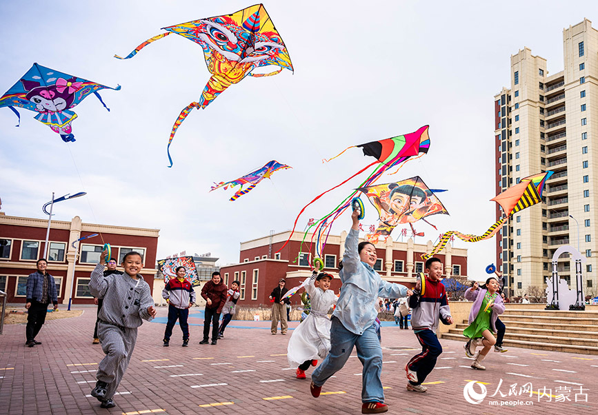 3月27日，呼和浩特市新城區北垣小學新雅校區第四屆校園風箏節活動現場，家長與學生們共同放飛風箏。丁根厚攝