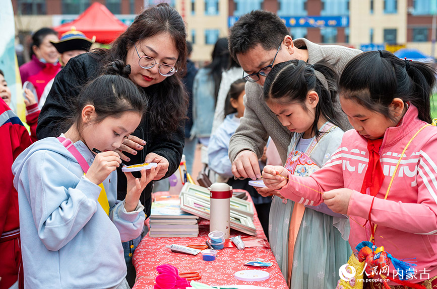 3月27日，呼和浩特市新城区北垣小学新雅校区第四届校园风筝节活动现场，学生们在体验掐丝珐琅制作技艺。丁根厚摄