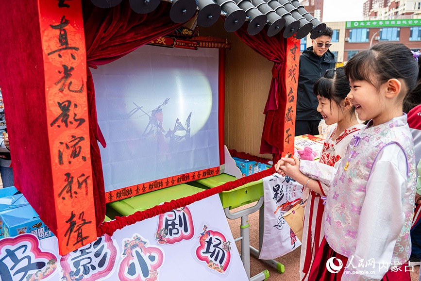 3月27日，呼和浩特市新城区北垣小学新雅校区第四届校园风筝节活动现场，学生在观看皮影表演。丁根厚摄