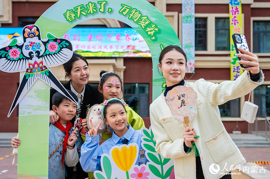3月27日，呼和浩特市新城区北垣小学新雅校区第四届校园风筝节活动现场，师生在自拍留影。丁根厚摄