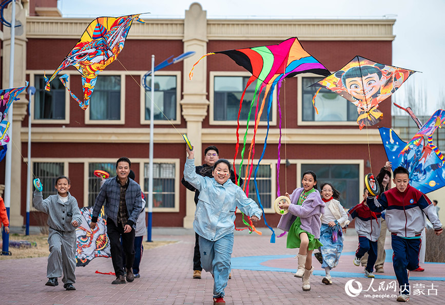 3月27日，呼和浩特市新城区北垣小学新雅校区第四届校园风筝节活动现场，家长与学生们共同放飞风筝。丁根厚摄