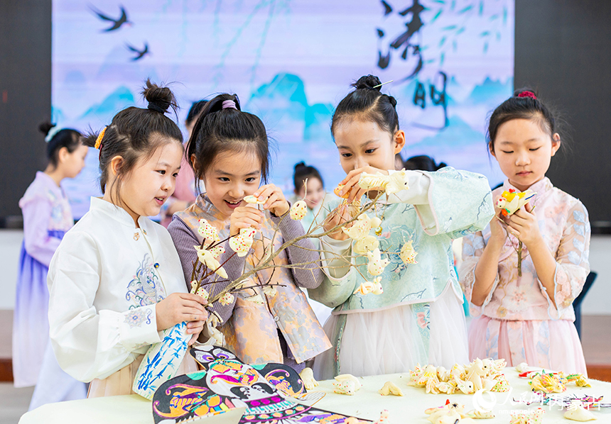 呼和浩特市玉泉區清泉街小學清明節主題活動現場，學生們將面塑“寒燕”懸挂枝頭，寓意春燕歸來。丁根厚攝