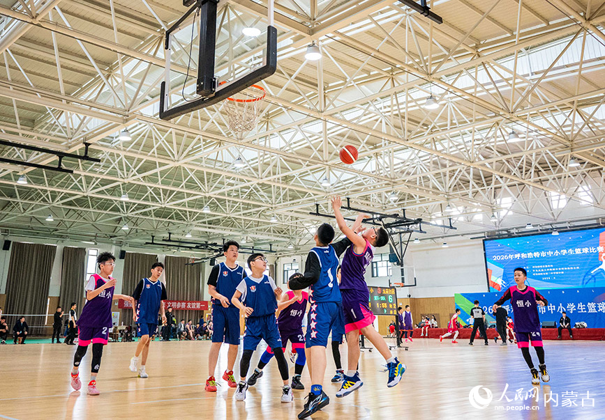 4月9日，内蒙古呼和浩特市玉泉区石头巷小学队和恒昌店巷小学队的球员在小学男子组比赛中争夺篮板球。丁根厚摄