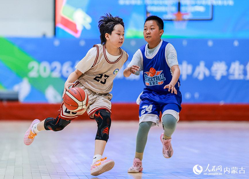 4月9日,呼和浩特市民族实验学校队球员在小学男子组比赛中运球突破。丁根厚摄