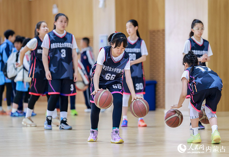 4月9日,内蒙古农业大学附属学校队球员在小学女子组比赛前进行热身。丁根厚摄