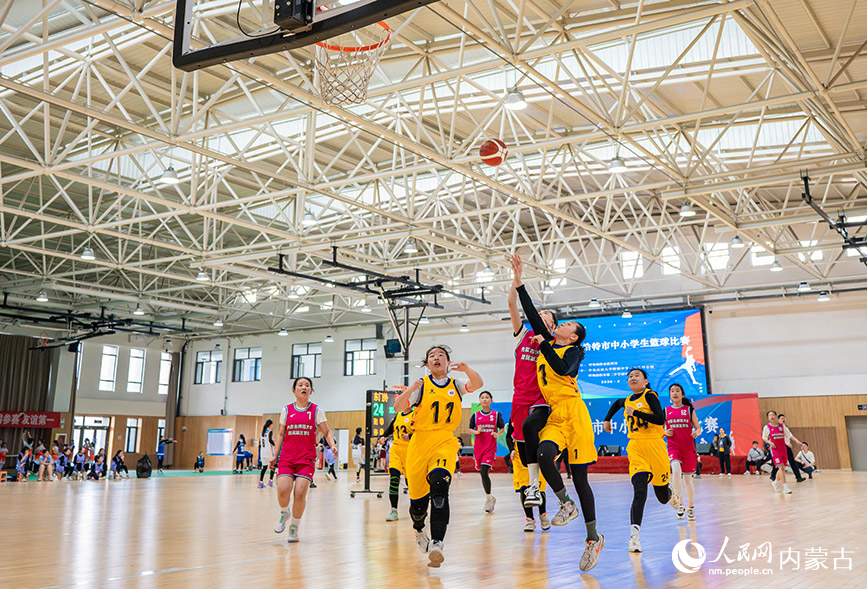 4月9日,内蒙古师范大学附属第三学校队球员在小学女子组比赛中投篮。丁根厚摄
