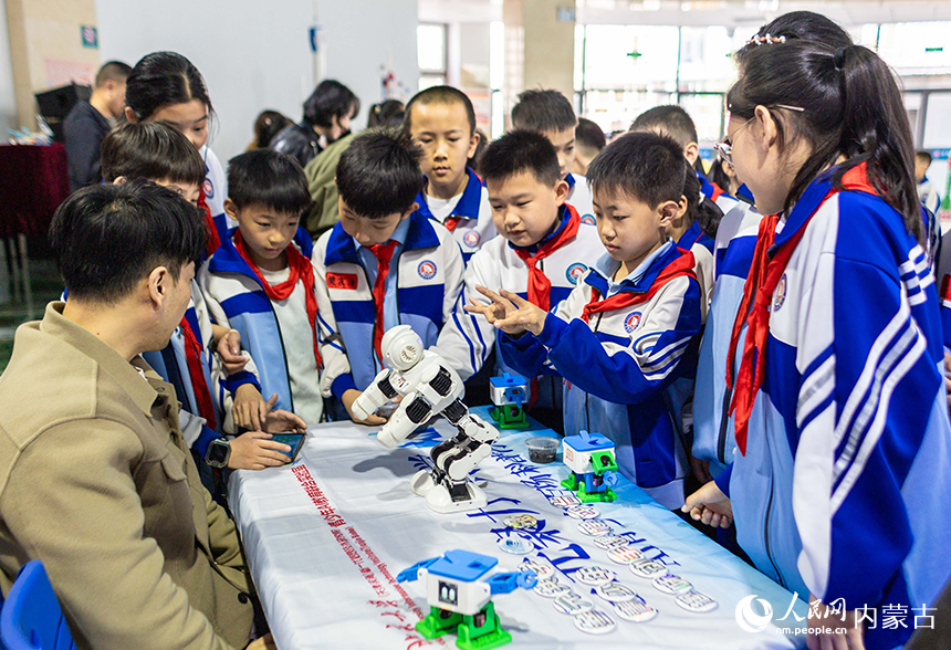 呼和浩特市玉泉区通顺街小学第一届科技节活动现场，学生们在观看机器人表演。丁根厚摄