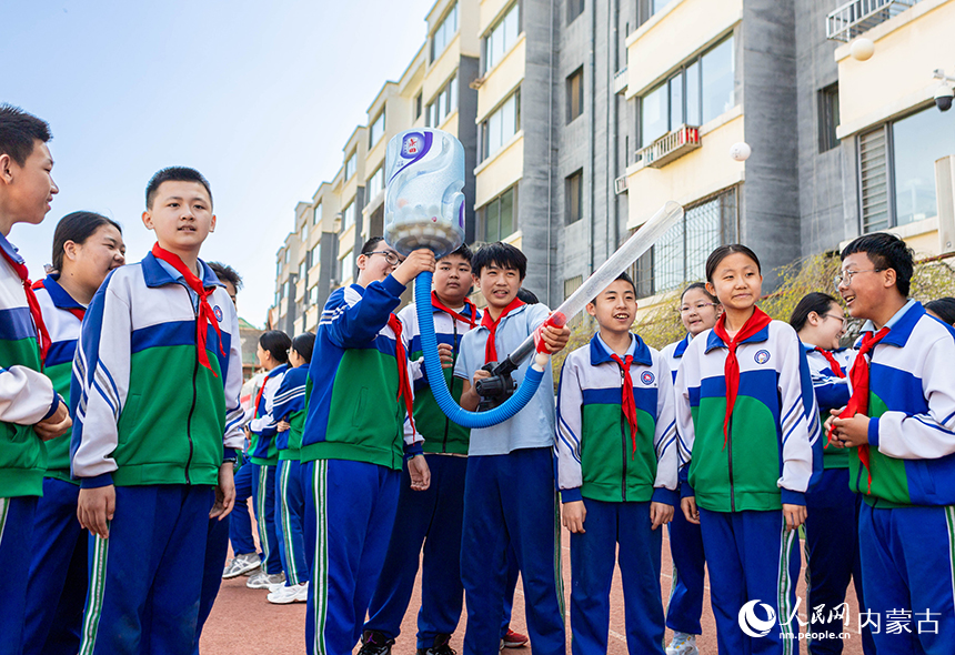呼和浩特市玉泉区通顺街小学第一届科技节活动现场，学生们在体验空气炮项目。丁根厚摄