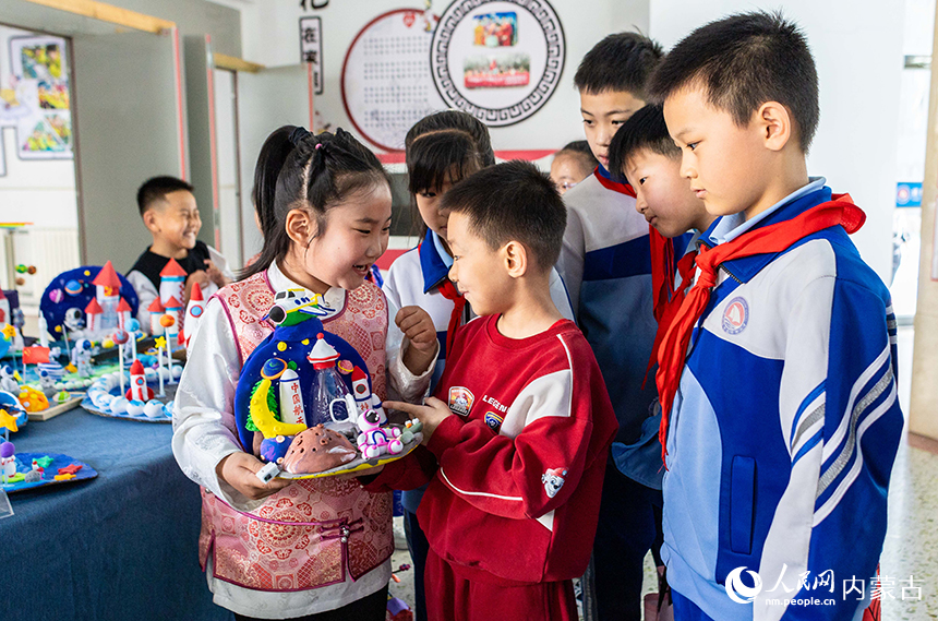 呼和浩特市玉泉区通顺街小学第一届科技节活动现场，学生们在参观科技手工作品展。丁根厚摄