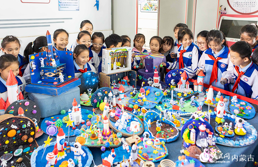 呼和浩特市玉泉区通顺街小学第一届科技节活动现场，学生们在参观科技手工作品展。丁根厚摄
