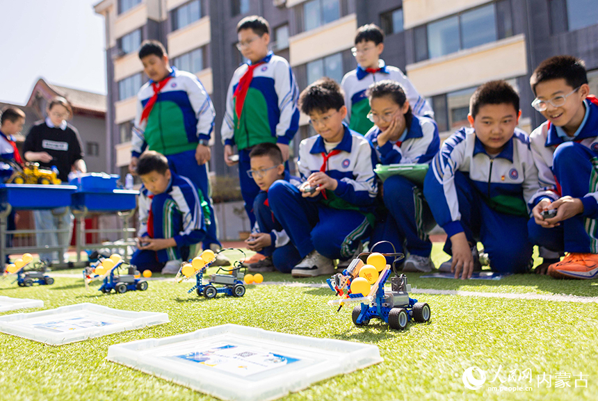 呼和浩特市玉泉区通顺街小学第一届科技节活动现场，学生们操控编程机器人完成挑战任务。丁根厚摄