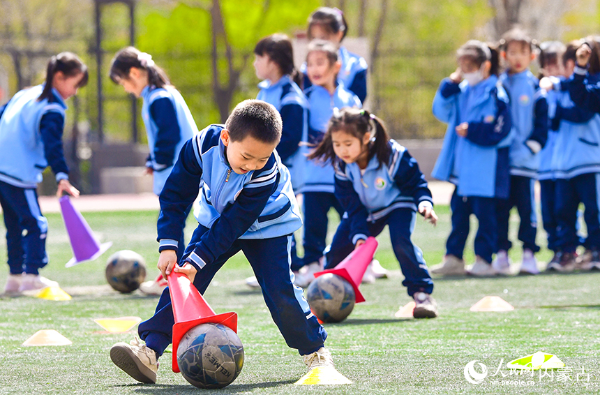 呼和浩特市赛罕区腾飞路小学学生在大课间参加足球趣味运动。王正摄