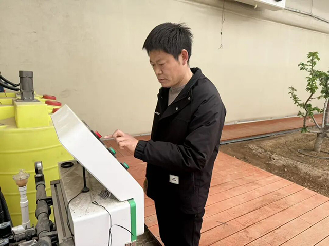 技術人員正在查看水肥一體化設備。王甜田攝