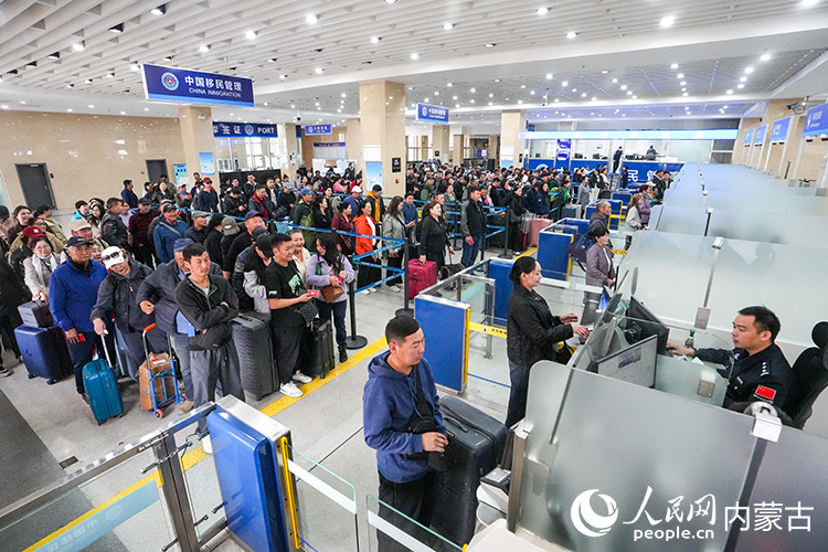 二連出入境邊防檢查站移民管理警察為入境旅客辦理通關手續。