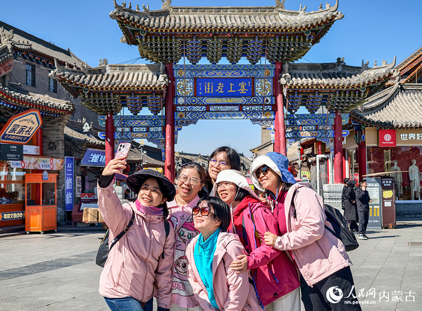 广东游客在呼和浩特市玉泉区塞上老街旅游休闲街区自拍留影。丁根厚摄