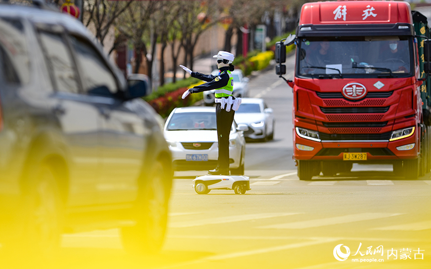 一款机器人交警在鄂尔多斯市准格尔旗薛家湾镇街头指挥道路交通。王正摄