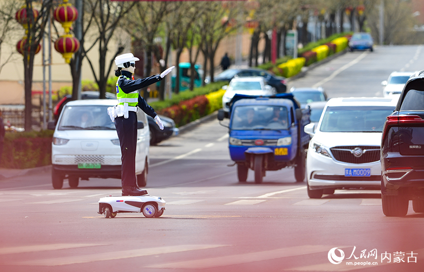 一款機器人交警在鄂爾多斯市准格爾旗薛家灣鎮街頭指揮道路交通。王正攝