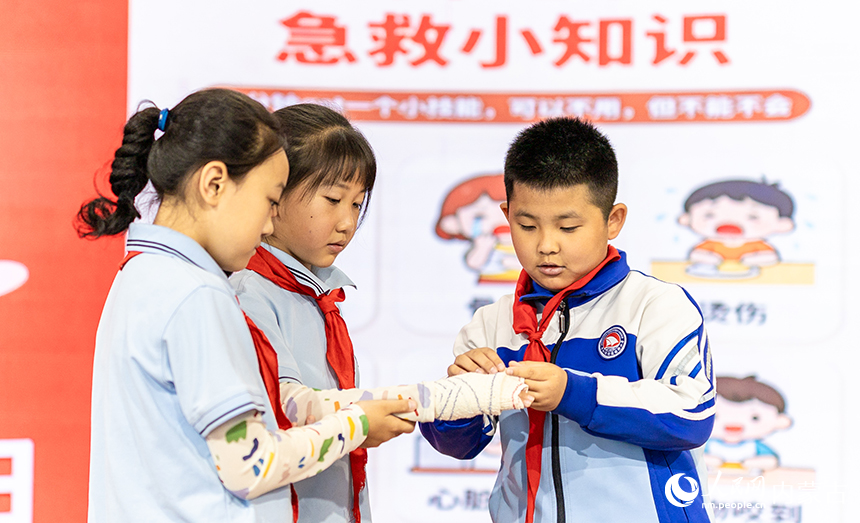 呼和浩特市玉泉区通顺街小学学生在练习救护包扎技能。丁根厚摄