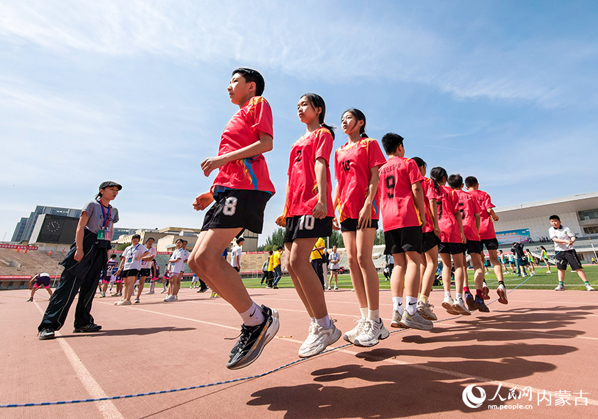 参赛小选手在呼和浩特市玉泉区中小学生田径运动会集体跳绳比赛中展开激烈比拼。丁根厚摄