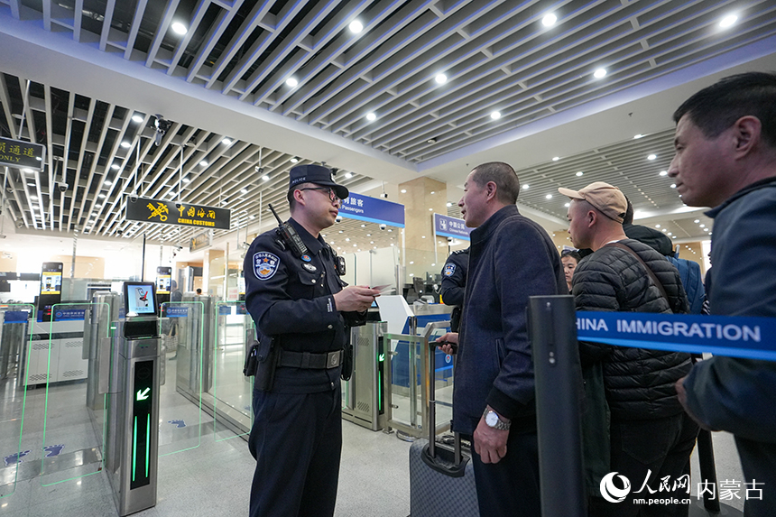 二连出入境边防检查站移民管理警察协助旅客从快捷通道通关。杨金烨摄