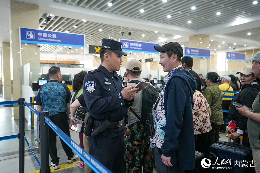 二连出入境边防检查站移民管理警察为旅客提供通关咨询。杨金烨摄