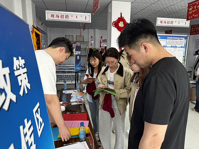 工作人员现场发放就业创业政策宣传单。