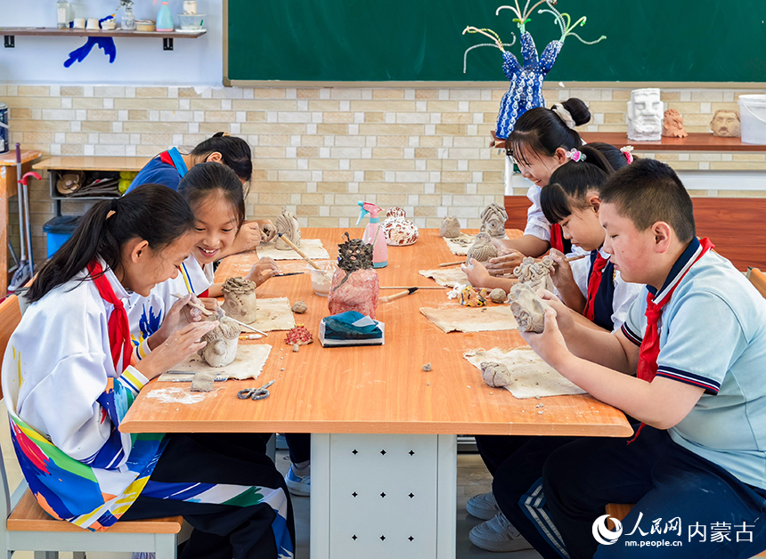 呼和浩特市玉泉区西菜园小学陶艺社团学生在制作陶艺作品。丁根厚摄