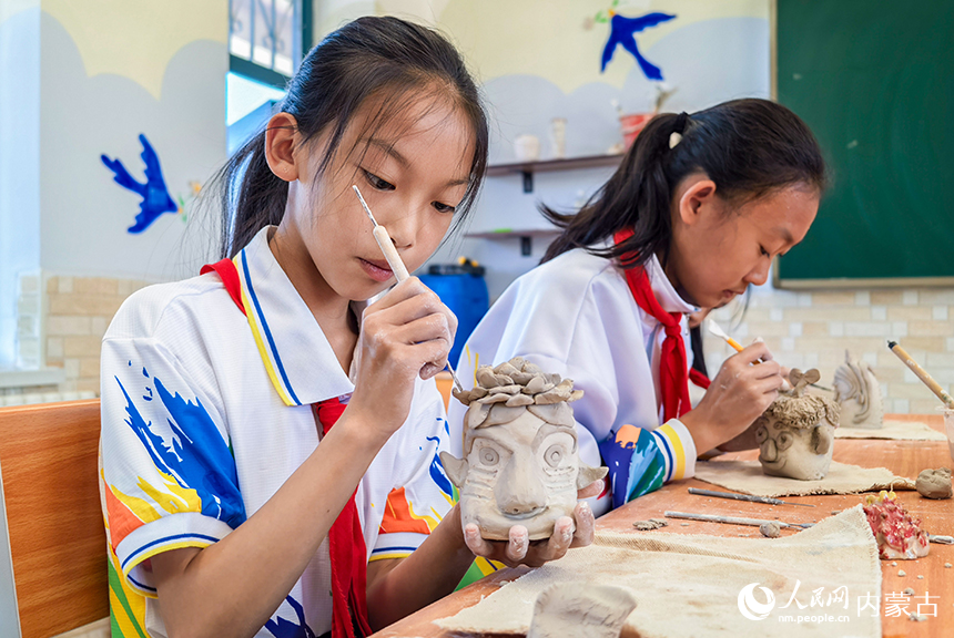 呼和浩特市玉泉区西菜园小学陶艺社团学生在制作陶艺作品。丁根厚摄
